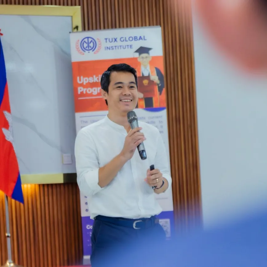A person holding a microphone speaking on the stage during annual job fair at TGI campus